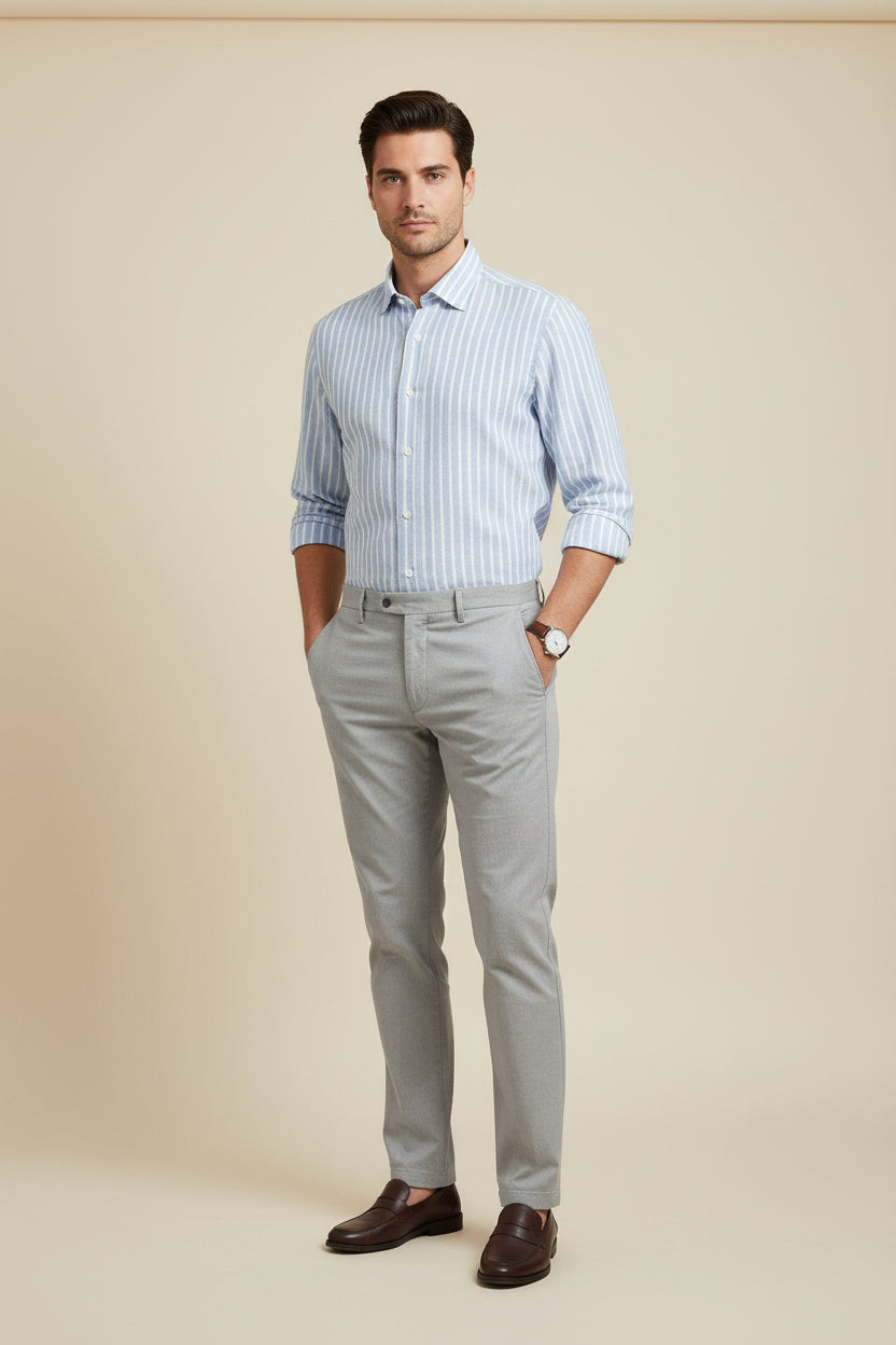 A light blue and white vertically striped long-sleeve dress shirt by Hechter, neatly folded on a dark wood background.