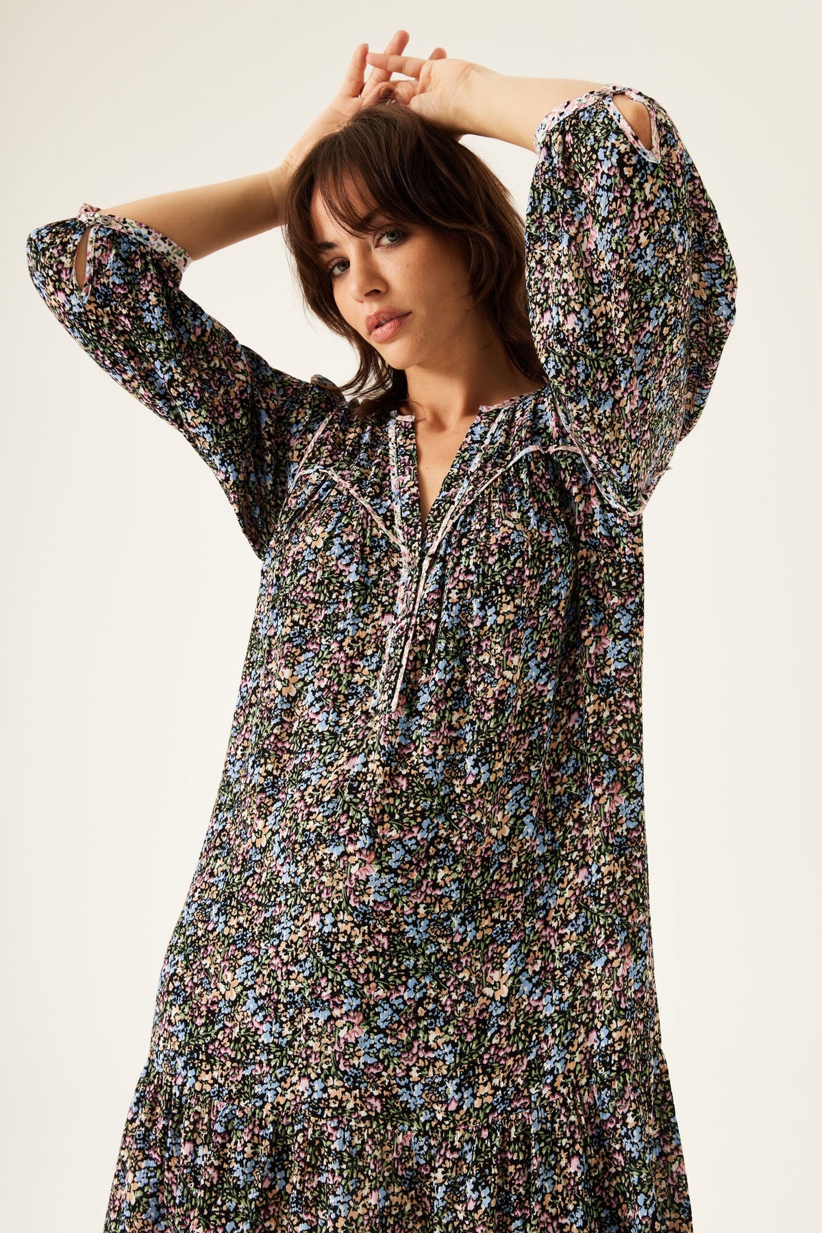 Woman wearing floral print dress with long sleeves and V-neck, stylish women's fashion clothing