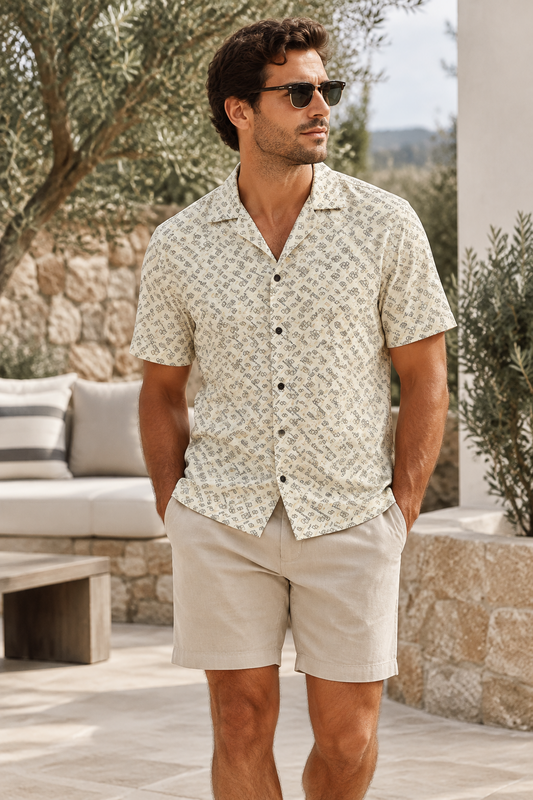 A folded Mechmoto Apparel dress shirt with a beige and black geometric pattern, featuring a black neck label and a black hangtag.