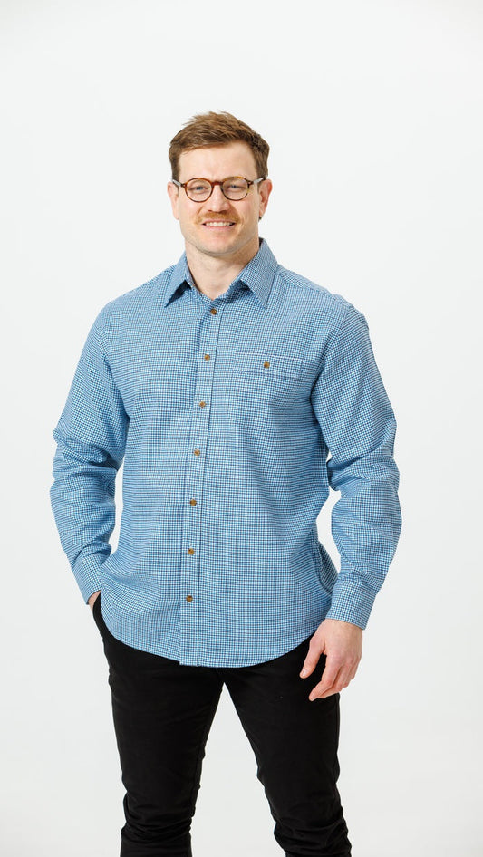 Man wearing a blue checkered shirt and glasses on a white background