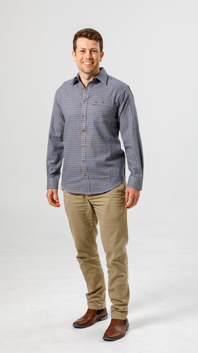 Man wearing a checkered shirt and beige pants on a white background