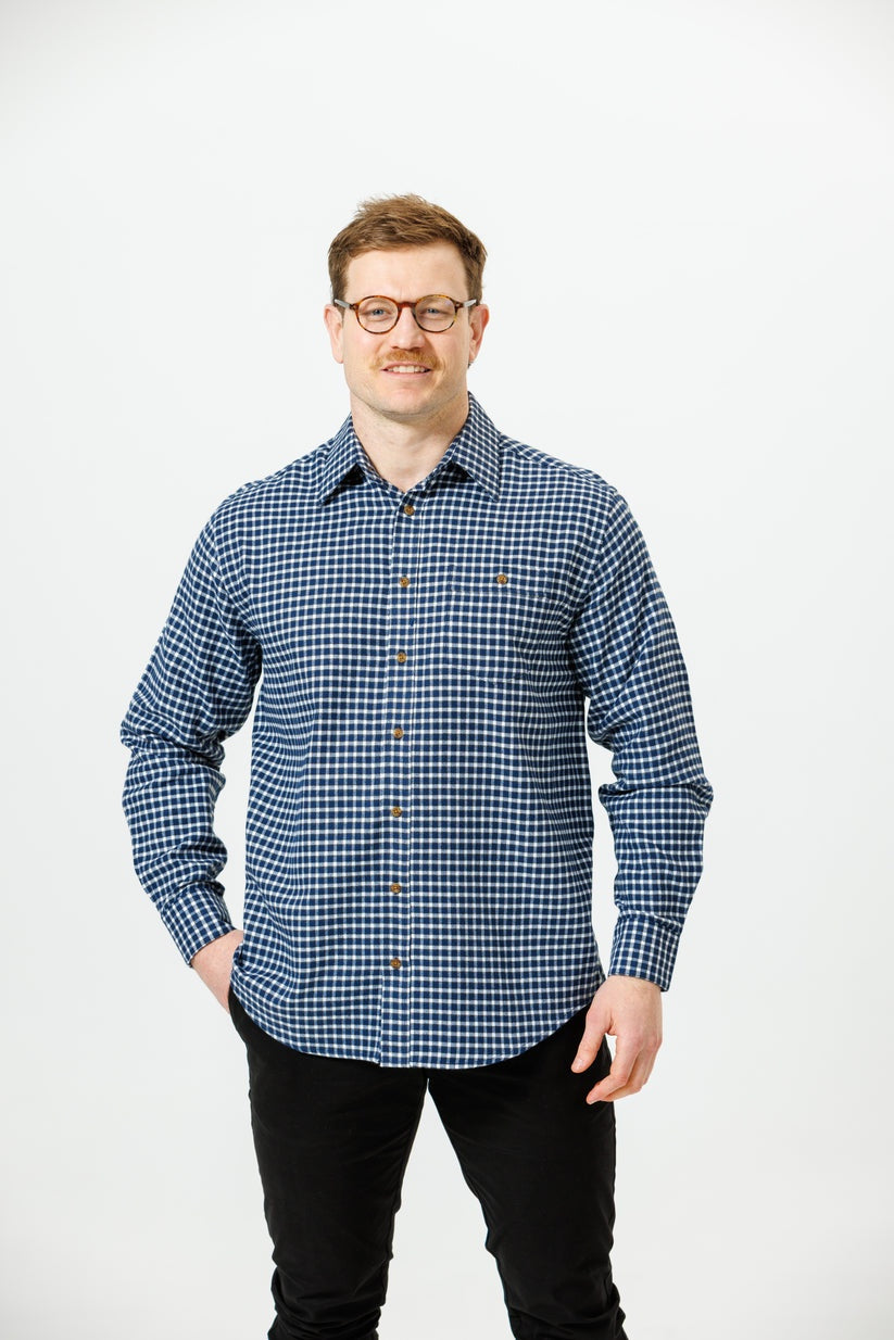 Man wearing a blue checkered shirt against a white background